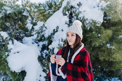 Woman holding coffee cup in snow