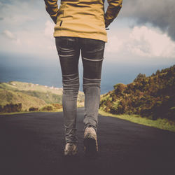 Low section of man walking on road