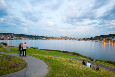 Rear view of people on lake against sky