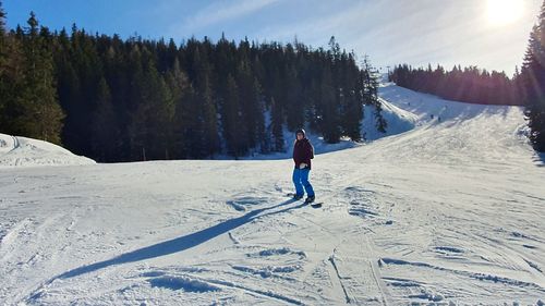 Full length of man skiing on snowcapped mountain against sky