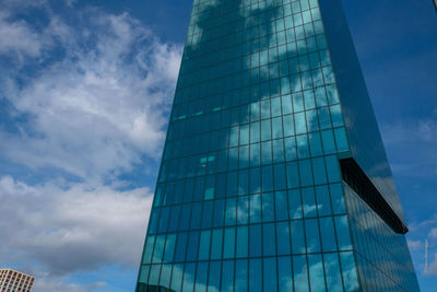 Low angle view of glass building against sky