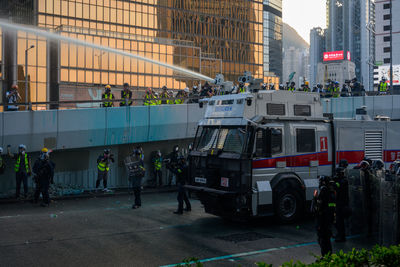 People on street against buildings in city