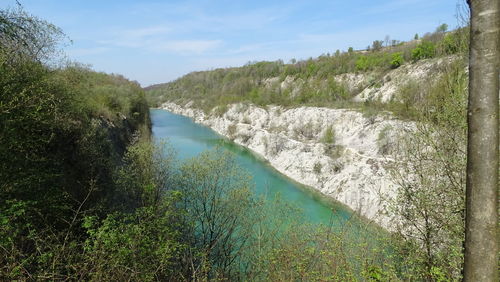 High angle view of river amidst trees against sky