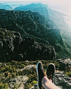 Low section of person on rock in mountains. 