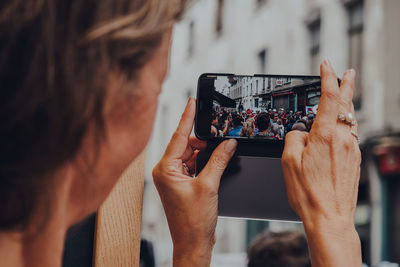 Midsection of woman photographing with mobile phone