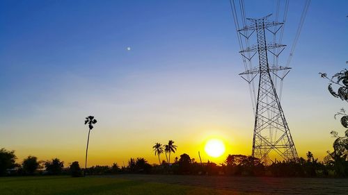 Low angle view of silhouette electricity pylon against sky during sunset