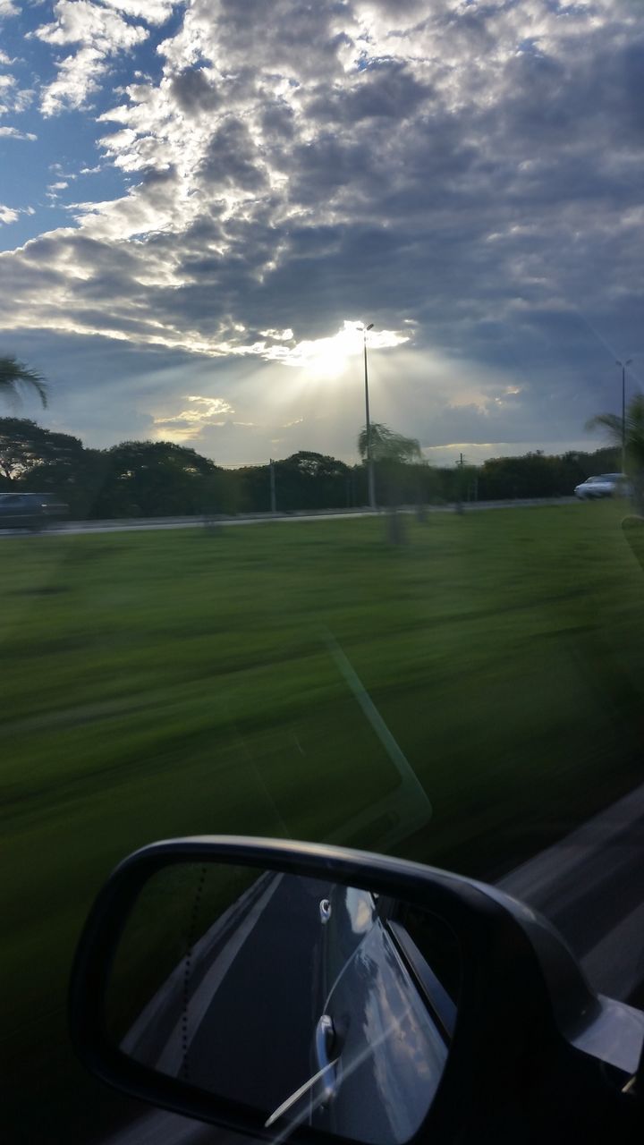 transportation, mode of transport, land vehicle, car, sky, vehicle interior, road, travel, sunlight, street, cloud - sky, day, nature, no people, built structure, street light, glass - material, sunbeam, mountain, on the move