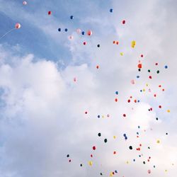 Low angle view of colorful balloons against sky