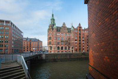 Canal amidst buildings against sky