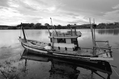 Boat moored in lake against sky