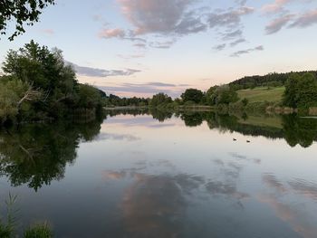 Scenic view of lake against sky at sunset