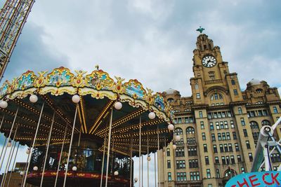 Low angle view of carousell against buildings