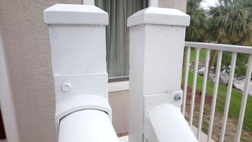 Close-up of white fence by railing