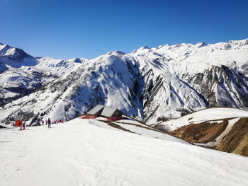 Scenic view of snowcapped mountains against clear blue sky