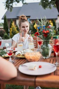 Portrait of smiling young woman with drink on table