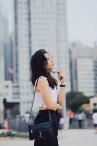 Young woman standing on street in city