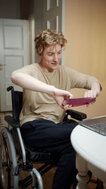 Smiling man exercising while sitting on wheelchair at home
