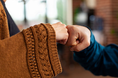 Close-up of man holding hands at home