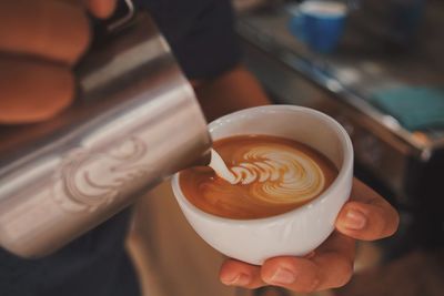 Cropped image of hand holding coffee cup