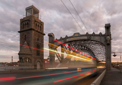 Bus light trail on sunset saint petersburg bridge named in russian after peter the great