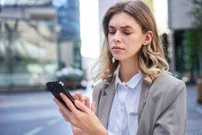 Portrait of young woman using mobile phone