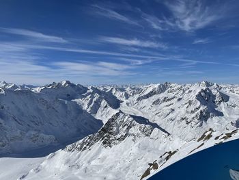 Scenic view of snowcapped mountains against blue sky