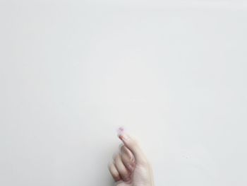 Close-up of person hand against white background