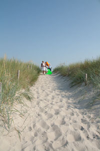 Person on beach against clear sky