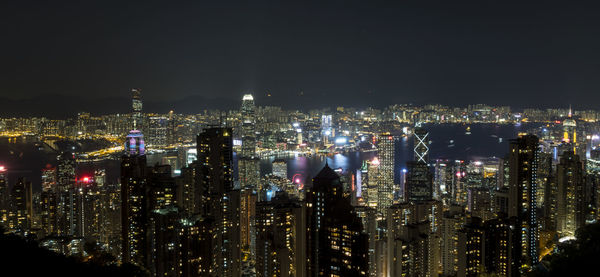 Illuminated cityscape against sky at night