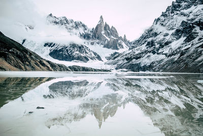 Glacial lake with snowcapped mountains in the background in winter