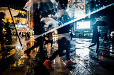 People walking on wet street at night