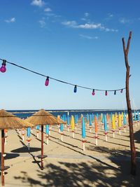 Clothes hanging on beach against blue sky