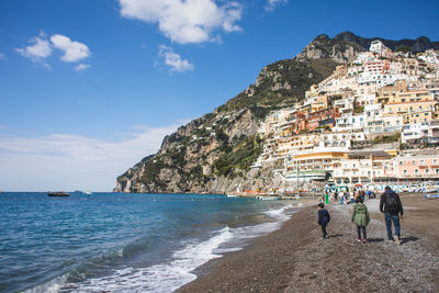 People at beach against sky