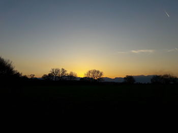 Silhouette landscape against clear sky during sunset