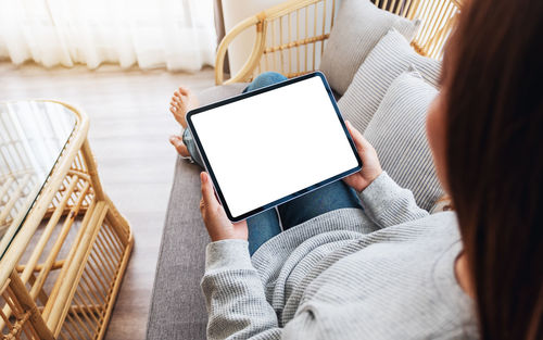 Midsection of woman using digital tablet