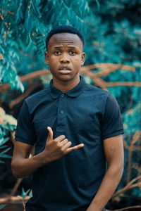 Portrait of man gesturing while standing outdoors