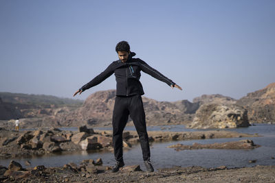 Full length of man standing on beach against clear sky