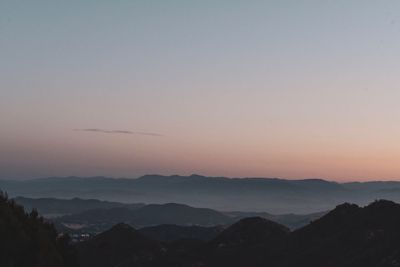 Scenic view of silhouette mountains against sky during sunset