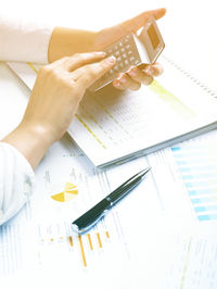 High angle view of woman holding pen on table