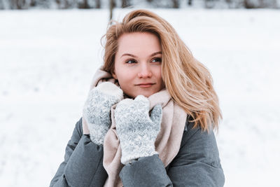 Portrait of young woman standing against clear sky