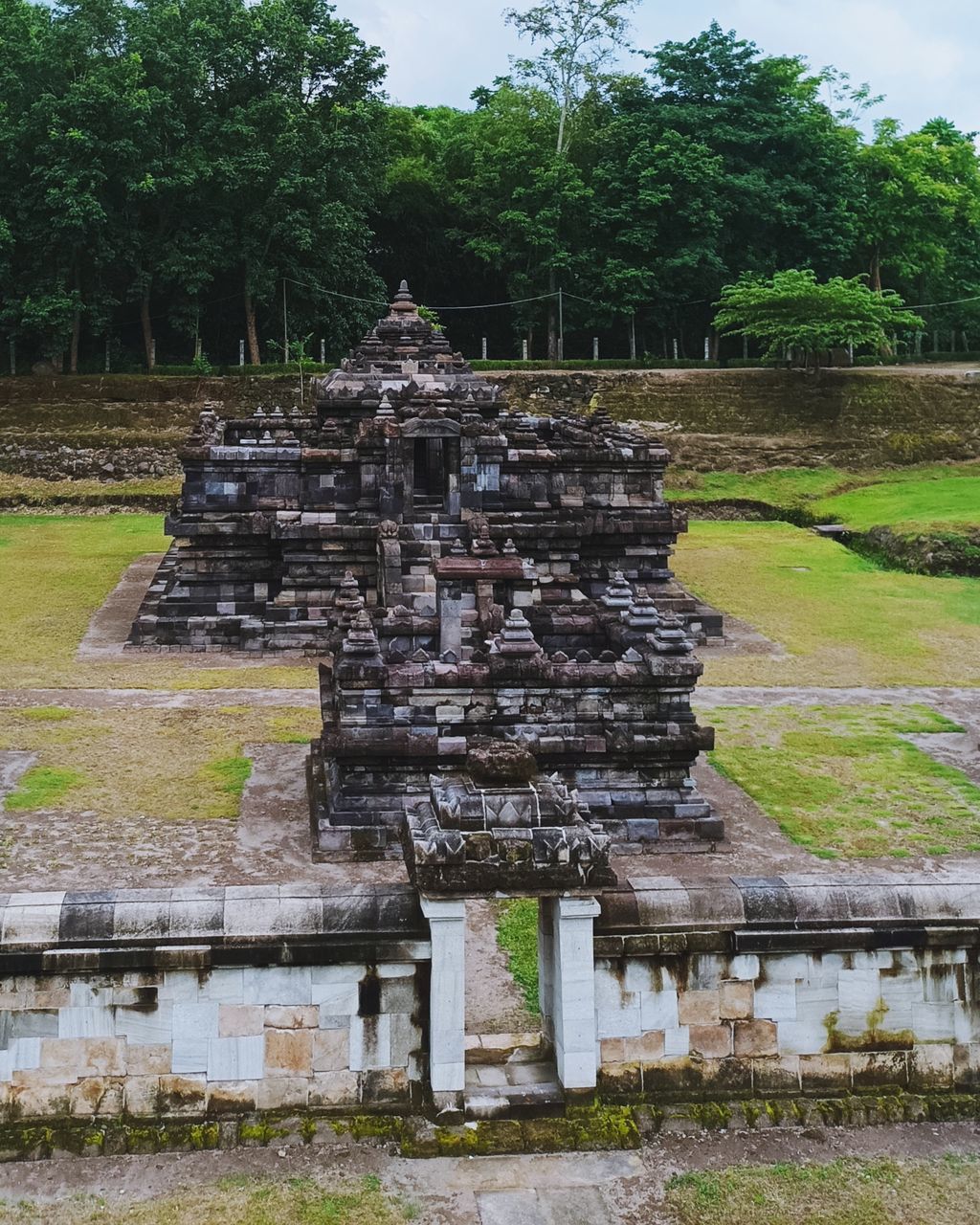 architecture, plant, tree, built structure, religion, archaeological site, temple - building, ruins, history, the past, belief, nature, spirituality, ancient, no people, travel destinations, place of worship, building, travel, ancient history, day, building exterior, outdoors, old ruin, stone material, temple, sky, tourism, tradition, grass, environment, old, ancient civilization, landscape, pagoda