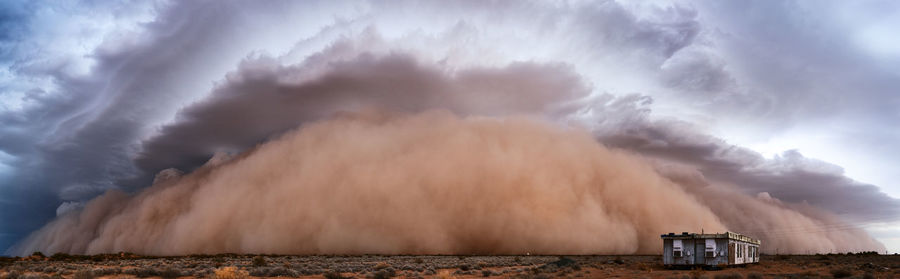 Panoramic view of hut against dust storm in desert