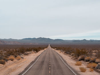 Empty road along countryside landscape