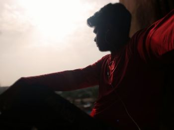 Side view portrait of young woman against sky during sunset