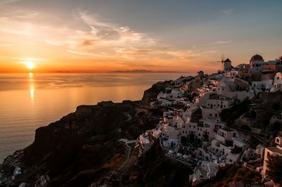 High angle view of buildings against orange sky at santorini