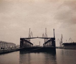 Silhouette of cranes against sky at sunset