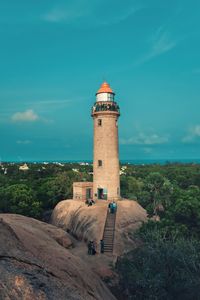 Lighthouse amidst buildings against sky