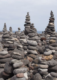 Stack of pebbles on beach against sky