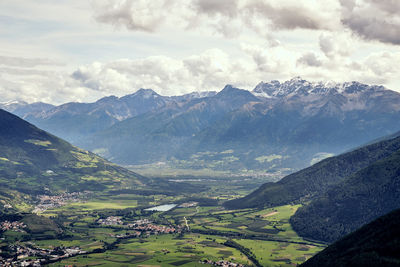 Scenic view of mountains against cloudy sky during winter