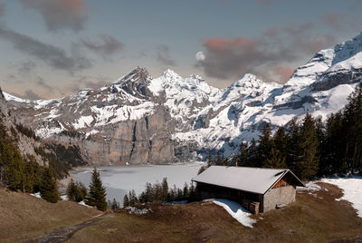 Panoramic winter or autumn landscape with full moon and frozen lake oeschinen and snow mountains
